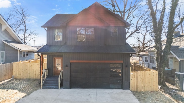 view of front of home featuring driveway, a shingled roof, an attached garage, and fence