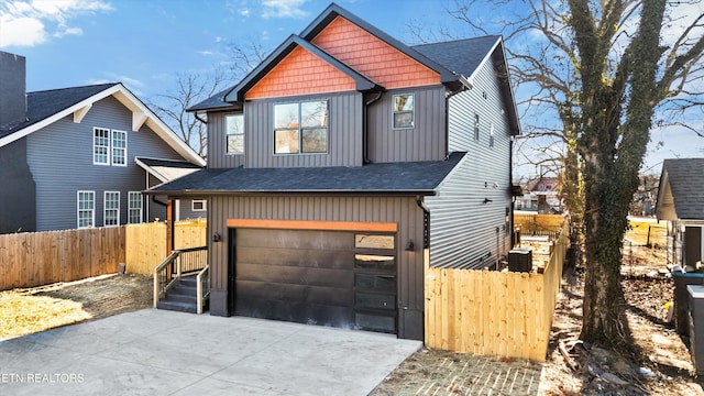 view of front of property with board and batten siding, fence, driveway, and an attached garage