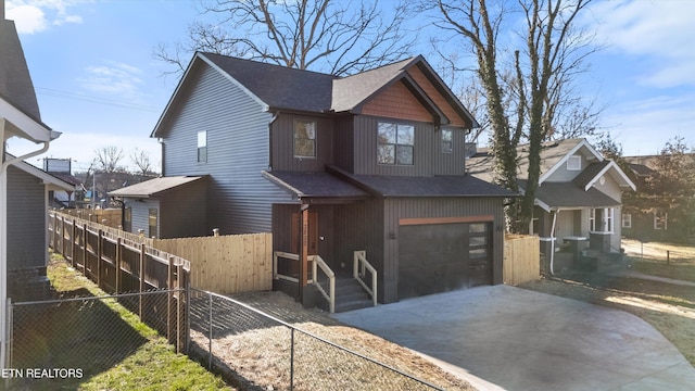 view of front of house featuring a garage, fence, and concrete driveway