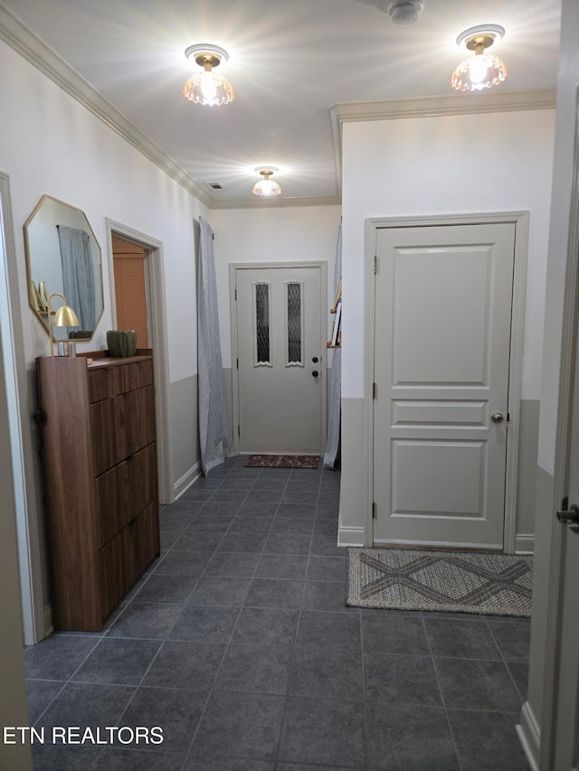 hallway with ornamental molding and dark tile patterned floors