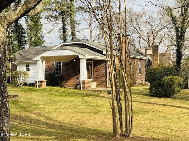 view of front of property with entry steps, brick siding, and a front lawn