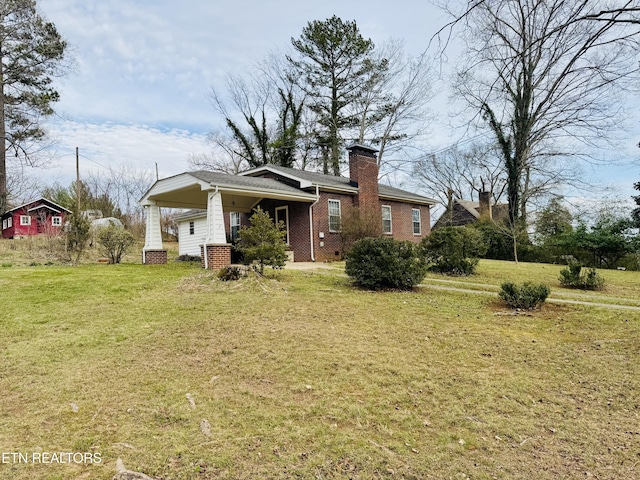 back of property featuring brick siding, a lawn, and a chimney