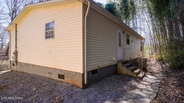 view of home's exterior with crawl space, central air condition unit, and entry steps