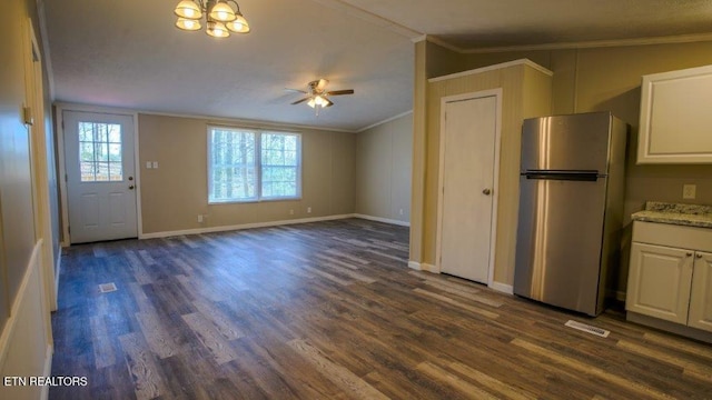 kitchen with white cabinets, dark wood-style floors, freestanding refrigerator, and crown molding