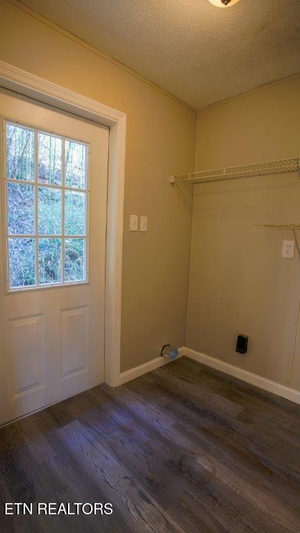 laundry room with laundry area, baseboards, a textured ceiling, and dark wood-style flooring