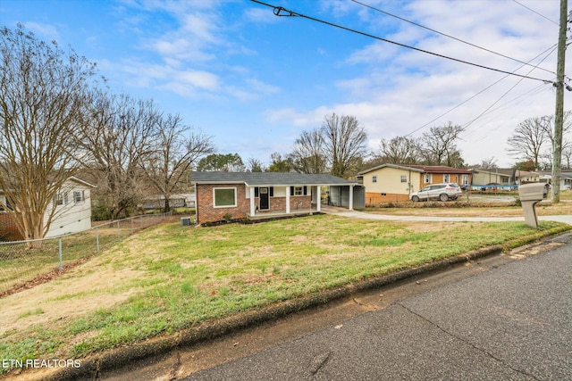 view of front of home with fence, a front lawn, concrete driveway, and brick siding