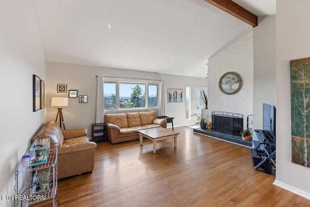 living area featuring wood finished floors, baseboards, high vaulted ceiling, beam ceiling, and a fireplace