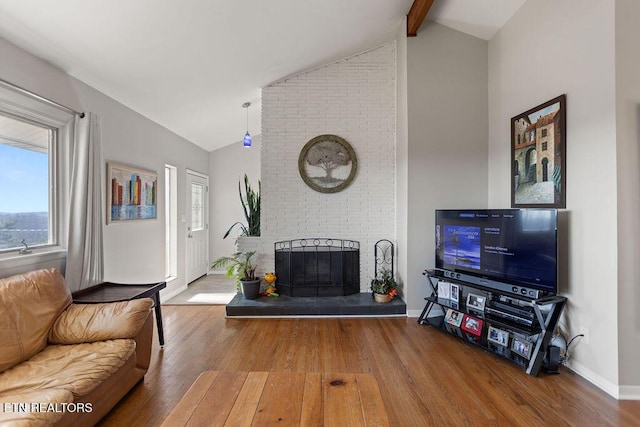 living room with baseboards, wood-type flooring, a fireplace, and vaulted ceiling with beams