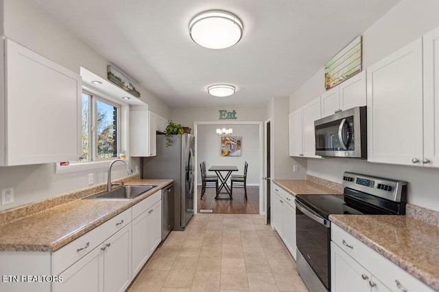 kitchen featuring a sink, white cabinetry, stainless steel appliances, light countertops, and light tile patterned floors