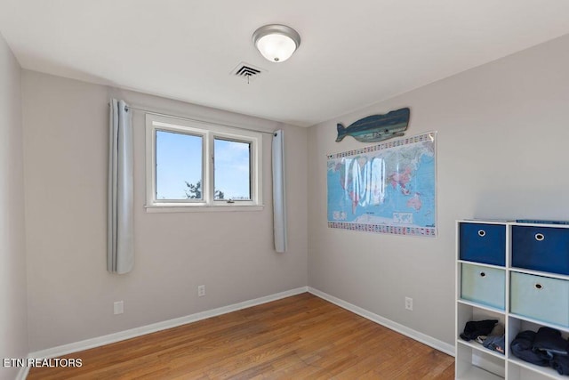 unfurnished bedroom featuring visible vents, baseboards, and wood finished floors