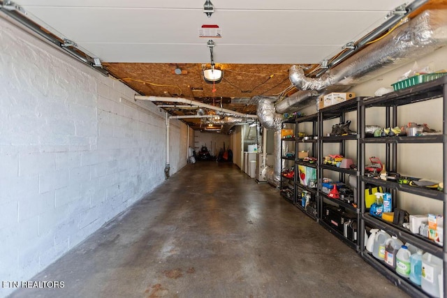 garage with concrete block wall and a garage door opener