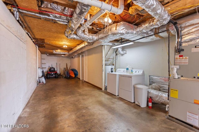 unfinished basement featuring heating unit and washer and clothes dryer