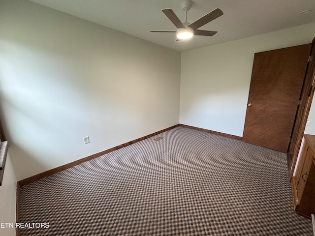 carpeted spare room with ceiling fan and baseboards