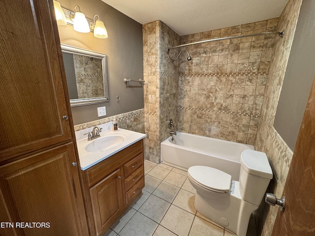 bathroom with a wainscoted wall, tile walls, a textured ceiling, vanity, and tile patterned floors