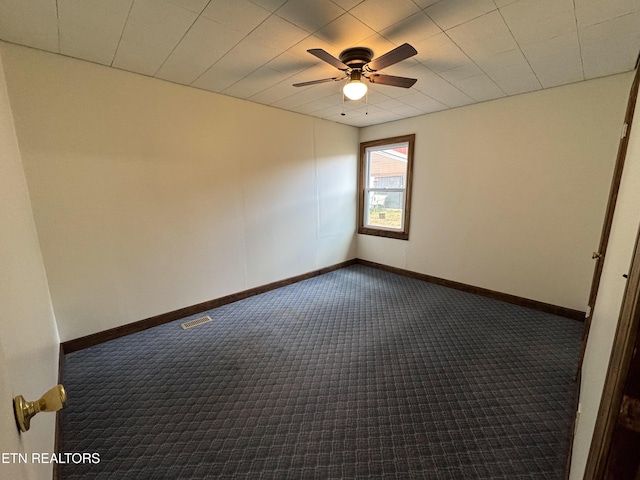 unfurnished room featuring baseboards, visible vents, and dark colored carpet