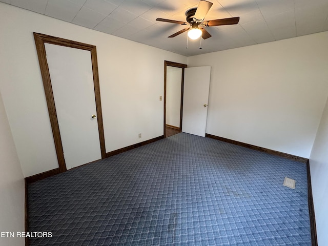 spare room with a ceiling fan, carpet, and baseboards