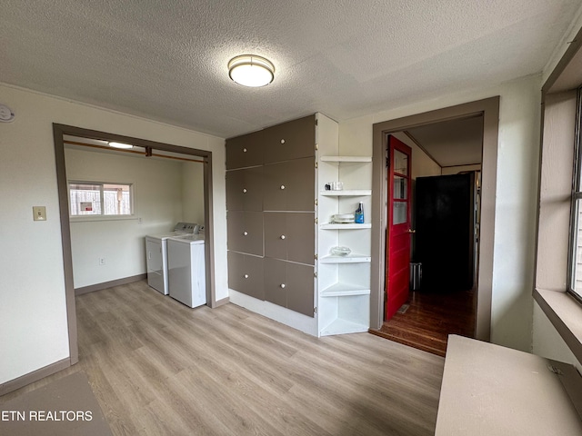 interior space with light wood-style floors, baseboards, a textured ceiling, and independent washer and dryer