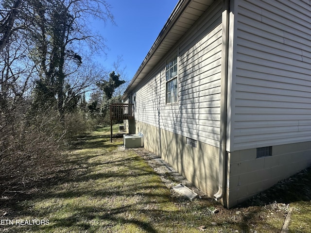 view of side of home with central AC unit and crawl space