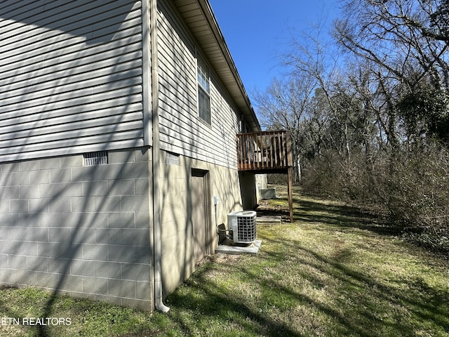 view of home's exterior with a lawn, a wooden deck, and central AC unit