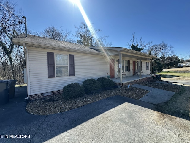 view of front of home with covered porch, roof with shingles, and crawl space