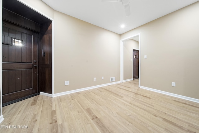 empty room with baseboards, visible vents, and light wood finished floors