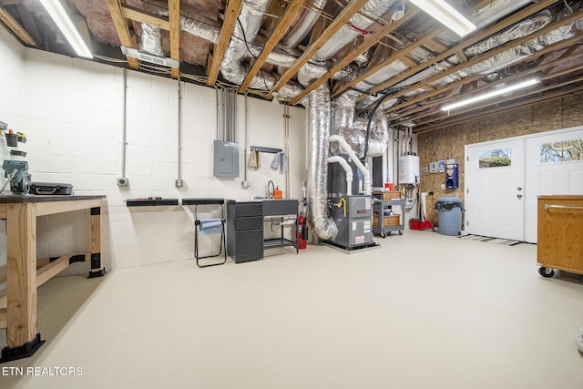 unfinished below grade area featuring electric panel, a sink, heating unit, water heater, and a workshop area