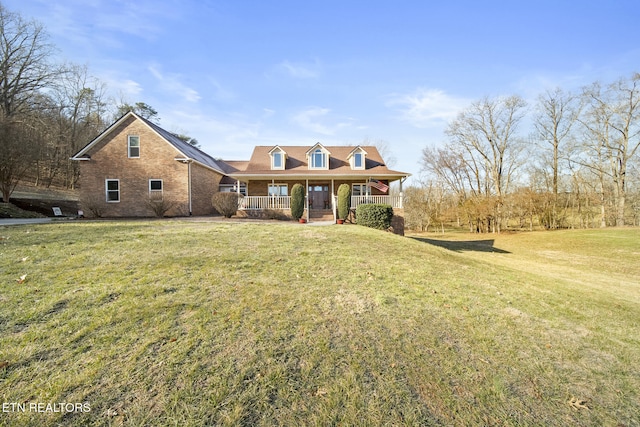 view of front facade featuring a porch, brick siding, and a front lawn