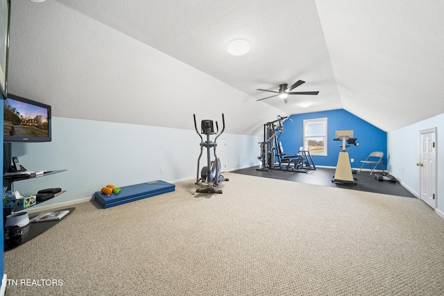 exercise room featuring lofted ceiling, a ceiling fan, baseboards, and a textured ceiling