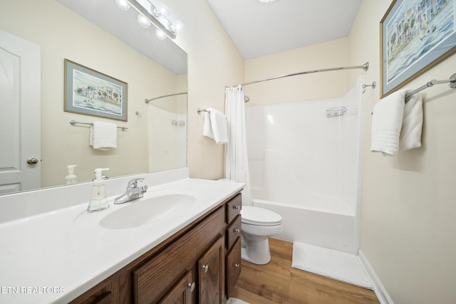 bathroom with shower / bath combo with shower curtain, toilet, wood finished floors, baseboards, and vanity