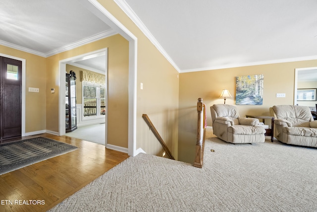 foyer with crown molding, baseboards, and wood finished floors