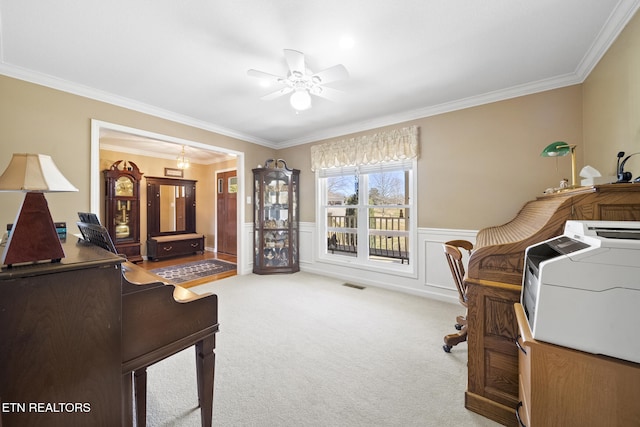 interior space with visible vents, a wainscoted wall, independent washer and dryer, a ceiling fan, and crown molding