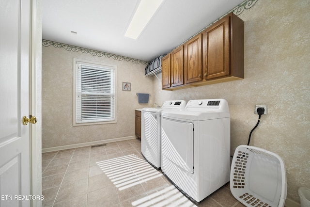 laundry room featuring visible vents, baseboards, light tile patterned floors, washer and dryer, and cabinet space