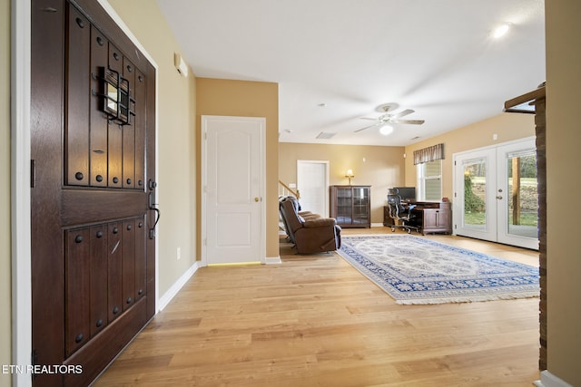 foyer with ceiling fan, french doors, baseboards, and light wood-style flooring