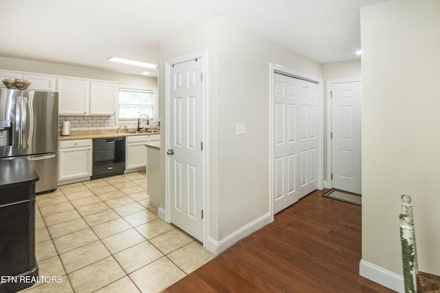 103 Branch Ln, Clinton, TN 37716 - kitchen with black dishwasher, stainless steel fridge, white cabinets, light countertops, and tasteful backsplash