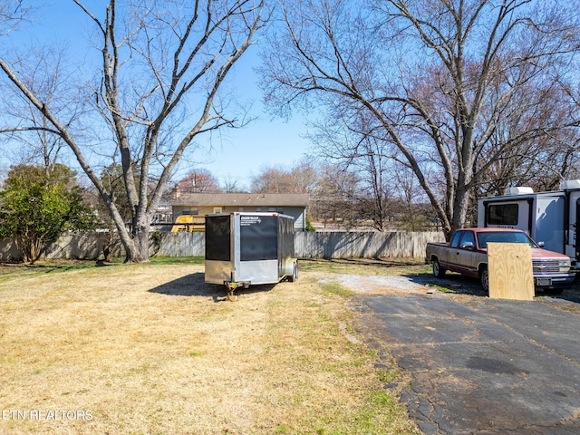 view of yard featuring an outdoor structure, a shed, and fence