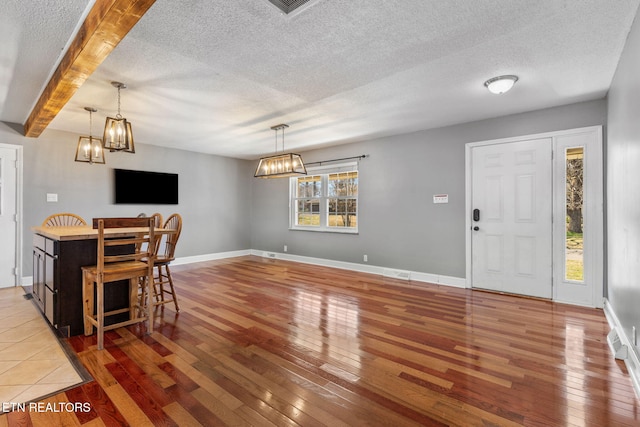 dining space with hardwood / wood-style floors, visible vents, and a chandelier