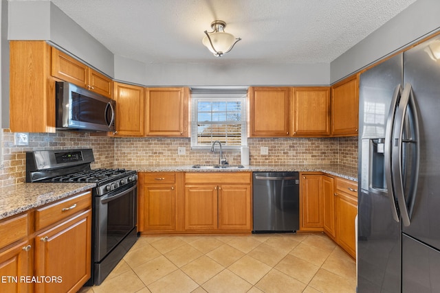 kitchen with brown cabinetry, stainless steel appliances, and a sink