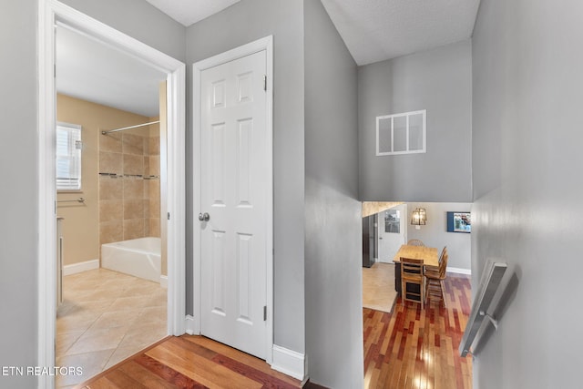 corridor featuring wood finished floors, visible vents, and baseboards