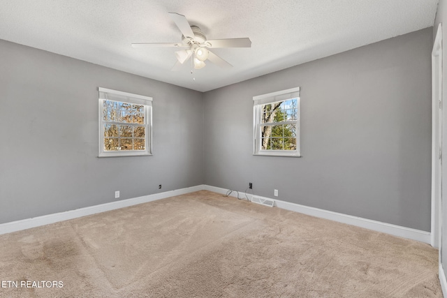 spare room featuring carpet flooring, a ceiling fan, baseboards, and a textured ceiling