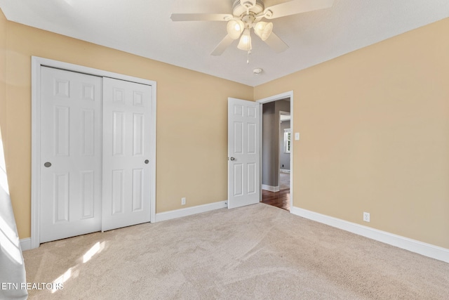 unfurnished bedroom with a closet, baseboards, and carpet flooring