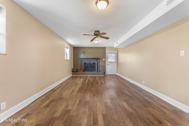 unfurnished living room with baseboards, plenty of natural light, and wood finished floors