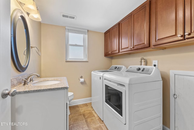 washroom with baseboards, visible vents, washing machine and clothes dryer, laundry area, and a sink