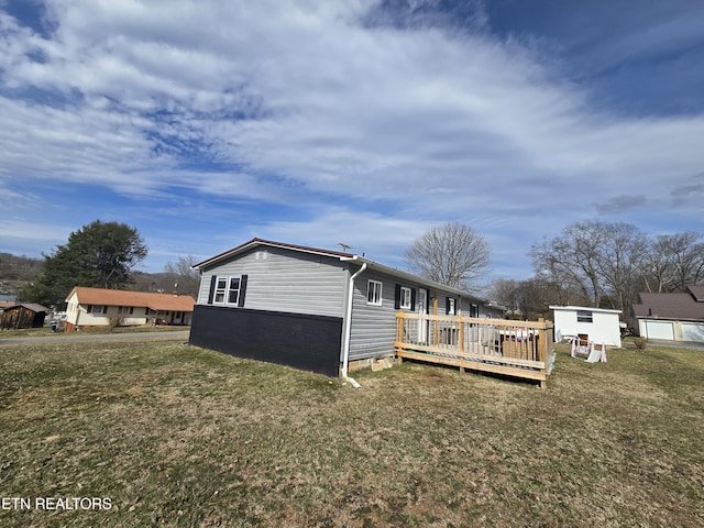 view of side of home with a yard and a wooden deck