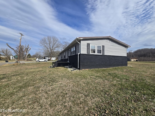 view of side of property with a yard and brick siding