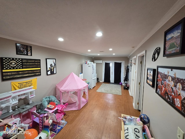 rec room featuring light wood-type flooring, crown molding, and recessed lighting