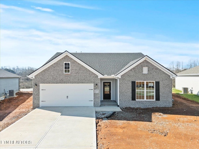 view of front facade featuring driveway, a garage, cooling unit, and brick siding