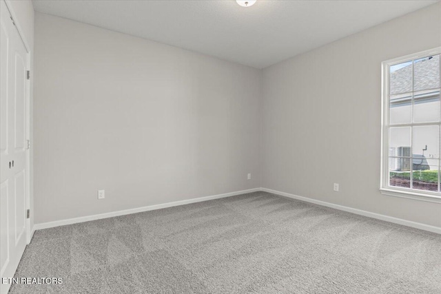 unfurnished room featuring carpet floors and baseboards