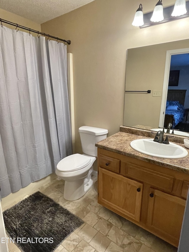 full bath featuring toilet, a textured ceiling, and vanity