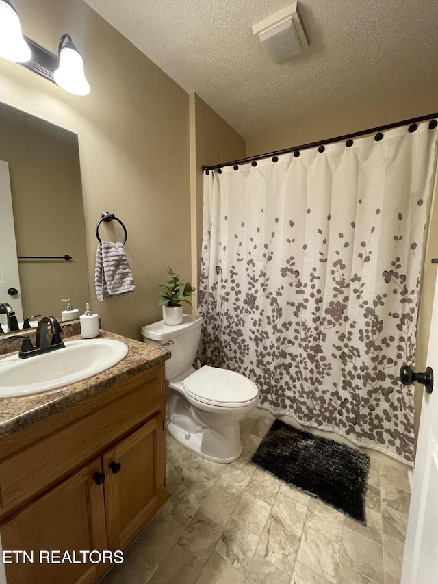 full bath with toilet, a shower with shower curtain, a textured ceiling, and vanity