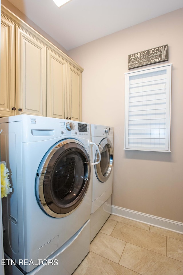 clothes washing area with cabinet space, light tile patterned floors, baseboards, and independent washer and dryer